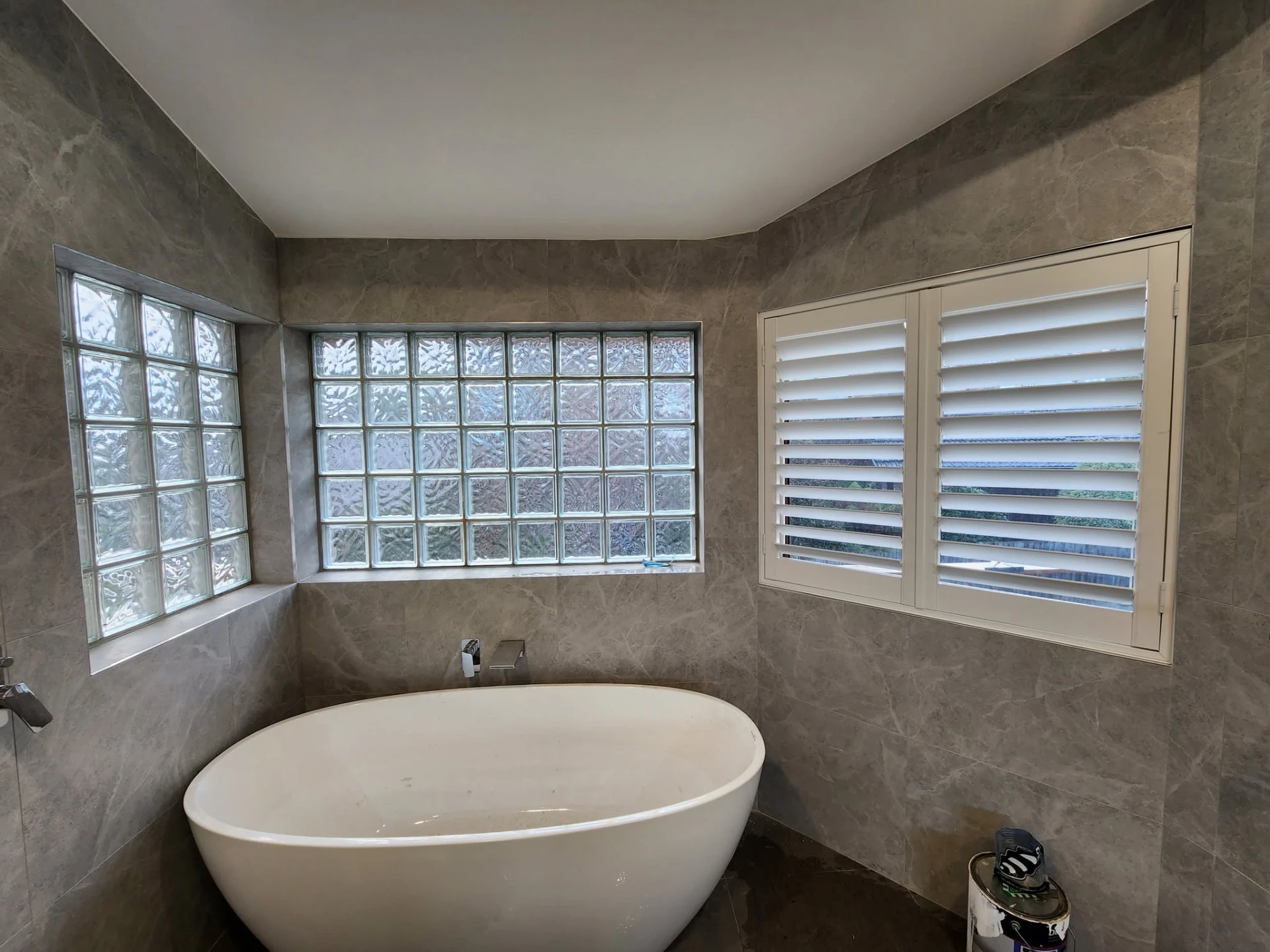 Bathroom with plantation shutters beside a freestanding bath